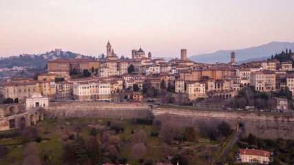 Obraz premium Bergamo, Italy. Drone aerial view of the old town during sunrise. Landscape at the city center, its historical buildings and the Venetian walls a Unesco world heritage