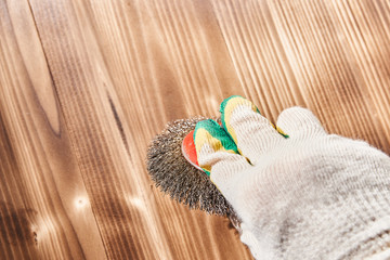 brushing a wooden board. stripping boards with a metal round brush.