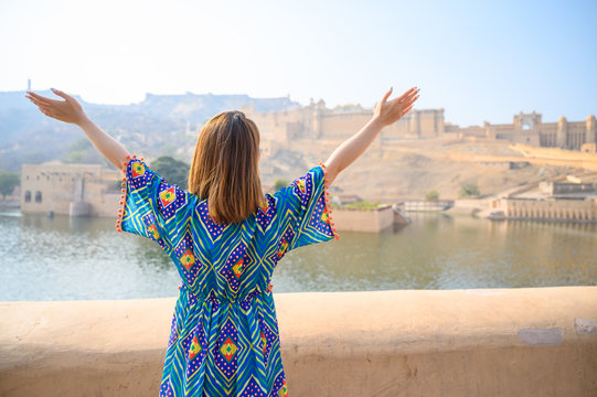Young woman in colorful dress enjoy the view of Amber palace in Jaipur in Rajasthan, India