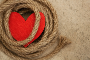 Heart and rope on a concrete floor. Sexual abuse concept , fatal love, dominant