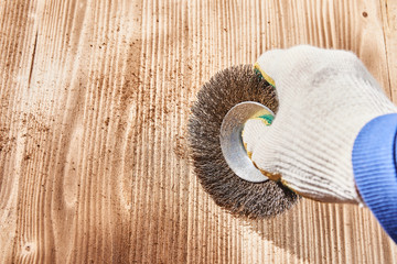 brushing a wooden board. stripping boards with a metal round brush.