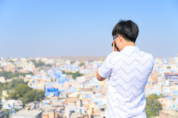 Fototapeta na wymiar Young traveler capture photo of the blue city of Jodhpur in Rajasthan, India