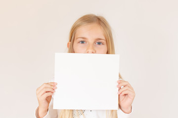 Fototapeta premium Blond girl holding a white paper