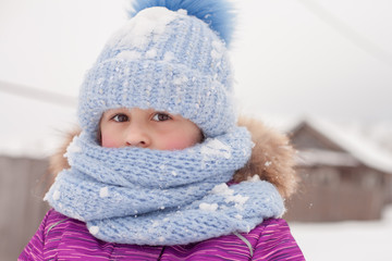 Little girl in the winter in the village