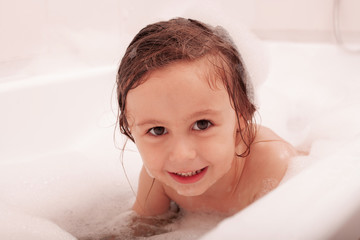 happy funny kid laughing and bathed in the bath