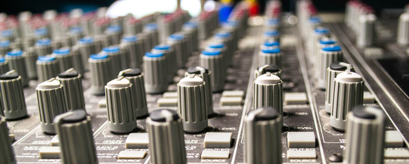Closeup of audio mixing console. Shot of shallow depth of field. Audio studio work.