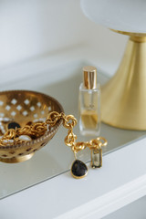 Fototapeta na wymiar Gold lapm gold accessories jewelry white table in cozy interior