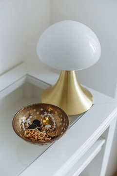 Gold lapm gold accessories jewelry white table in cozy interior