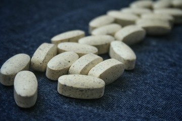 White medical pills on blue background.