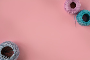 Skeins of colored yarn on a peach background. Yarn for knitting on a pink background. Yarn on a...