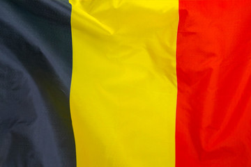 Fabric texture flag of Belgium. Flag of Belgium waving in the wind. Belgium flag is depicted on a sports cloth fabric with many folds. Sport team banner.