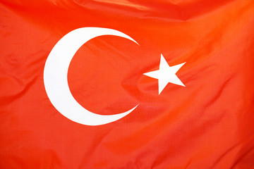 Fabric texture flag of Turkey. Flag of Turkey waving in the wind. Turkey flag is depicted on a sports cloth fabric with many folds. Sport team banner.