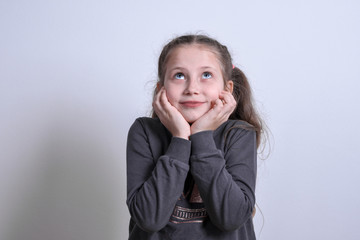 Portrait of a little white girl moony,dreamy on a gray background