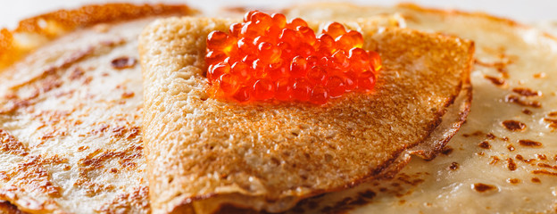 Stack of russian pancakes blini with red caviar, fresh sour cream