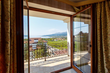 view from the room of the cottage on the sea and mountains, which can be seen through the open door. 