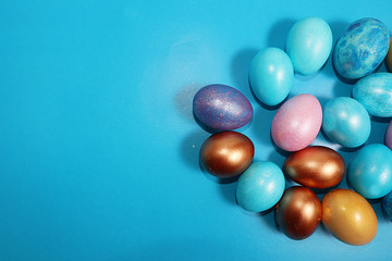 Decorated golden and blue easter eggs on a blue background. Minimal holiday concept. Happy easter background. Creative painting of eggs, place for text, postcard, banner for the screen.