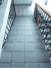 Gray stairway with brown wooden handrails