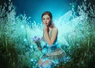 Art photo fantasy pixie butterfly. young fairy with glow wings holds bouquet flower. dark blue...