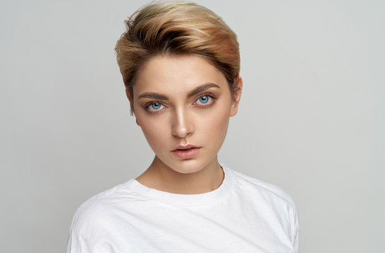 Portrait of young model with short hair isolated on gray background