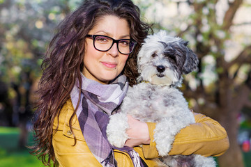 Beautiful Smiling Woman Hugging  Her Cute  Dog in the Park .Pet and Owner Outdoor in the Nature