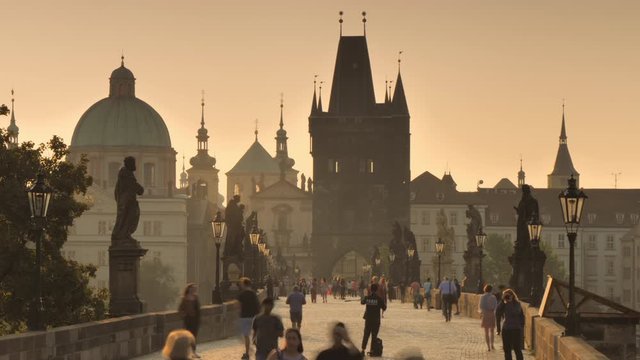 prague 01/09/2018: tourists visit and walk on prague charles bridge at sunrise time lapse