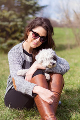 Beautiful Smiling Woman Hugging  Her Cute  Dog in a Spring Garden .Pet and Owner Outdoor in the Spring