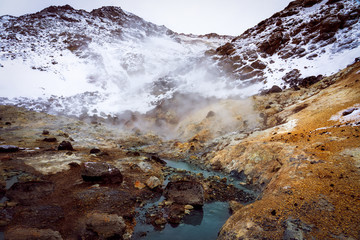 warm river and mountains in snow in krysuvik seltun on reykjanes peninsula in Iceland winter landscape .