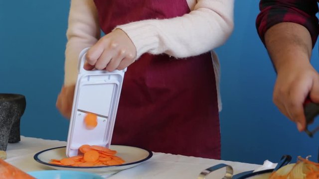 Two Cooking Students Learning To Use Mandolin Slicer