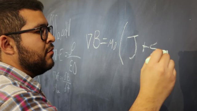 Advanced physics mexican student sketching equations on blackboard