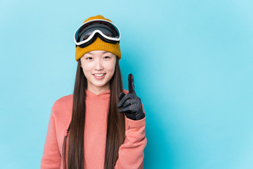 Young chinese woman wearing ski clothes isolated showing number one with finger.