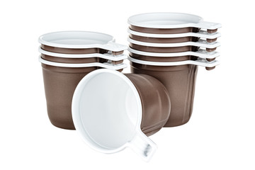 Obraz premium Standing three and five unused disposable white plastic mugs with brown satin texture on the outside and one lying same mug in the foreground isolated on white background