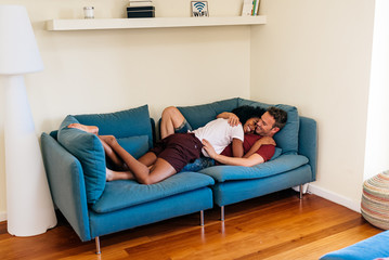 Idyllic multiethnic couple enjoying each other on sofa at home