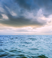 Obraz premium low dramatic clouds over dark sea in sunset