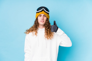 Young caucasian man wearing a ski clothes isolated  smiling and raising thumb up