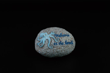 Round ornamental stone with octopus and welcome message, with gray background