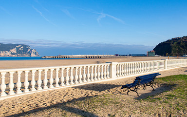 Landscape of bench next to the beach with a white balustrade