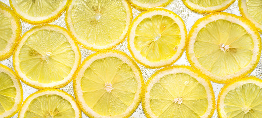 Slices of lemon in water with air bubbles