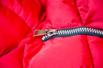 Metallic zipper on a red women's jacket.