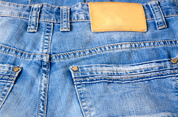 Part of jeans trousers with pockets and buttons. Clothing label.