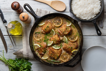 lemon butter chicken in iron skillet with cooked rice