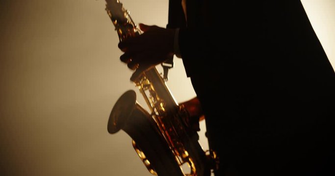 Cool saxophonist wearing a suit and performing an amazing solo. Musician doing a concert with jazz band - music, arts concept 4k footage