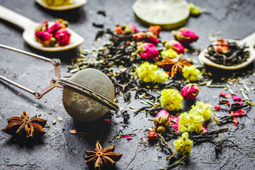 Tea herbs and spoons on grey background