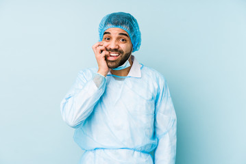 Young surgeon latin man isolated Young dbiting fingernails, nervous and very anxious.