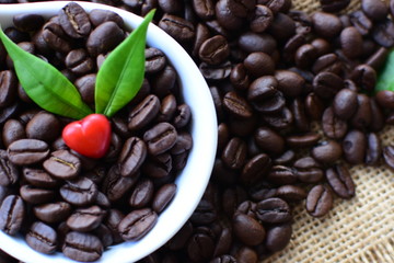Coffee beans decorated with red heart and green leaves