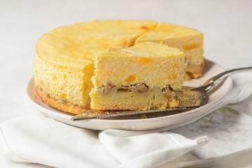 Pumpkin cheesecake with caramel sauce, light grey stone background. Selective focus. 