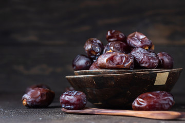 Juicy organic medjool dates on dark brown concrete background. Copy space, selective focus.