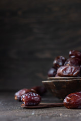 Juicy organic medjool dates on dark brown concrete background. Copy space, selective focus.