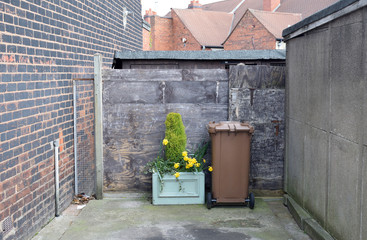 Flowers and Plants in Planter next to Wheelie Waste Bin in empty Cul-de-Sac 