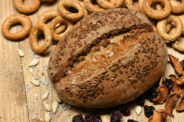 bread and bagels with seeds and salt on wood background