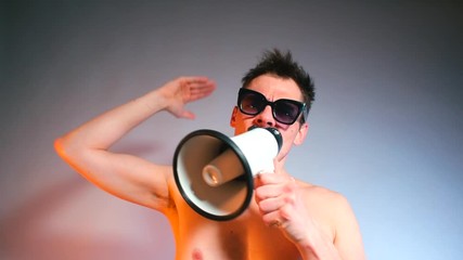 blogger in black glasses without shirt is shouting into megaphone.